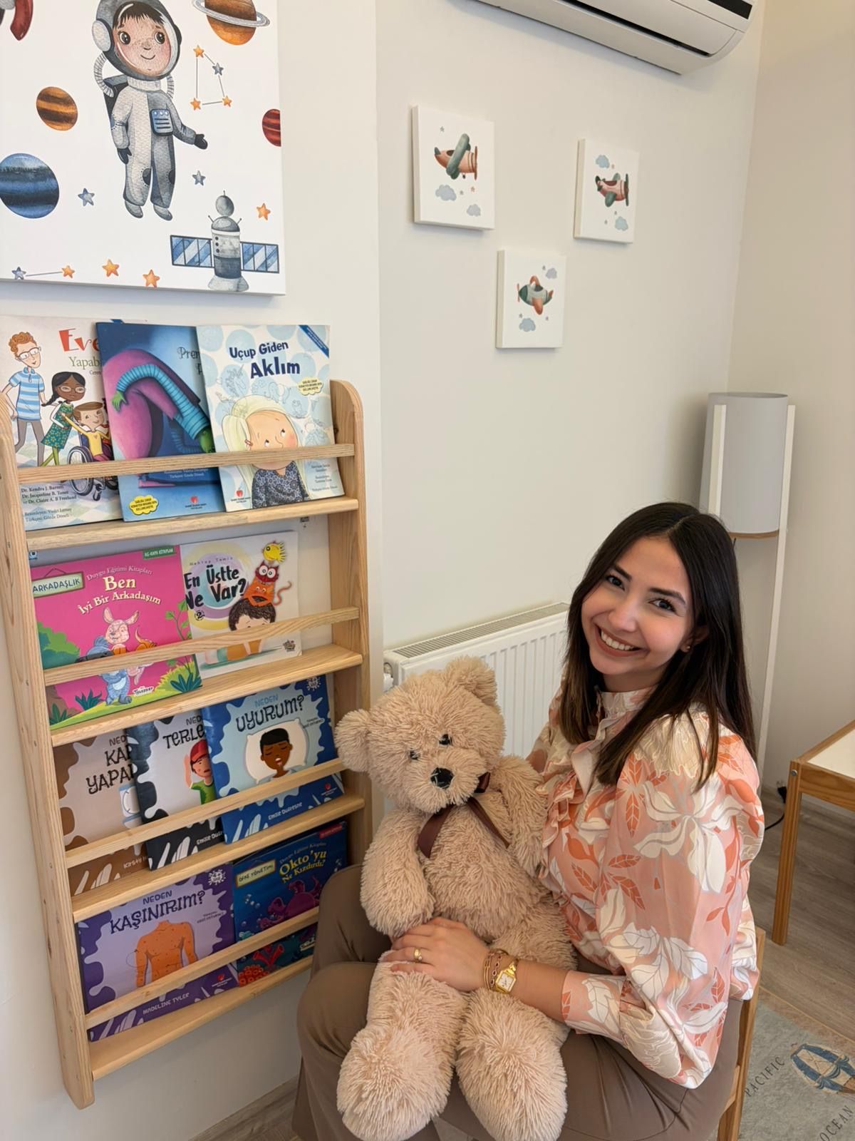 Çocuk kitaplığında oyuncak ayıyla, kliniğin çocuk köşesi