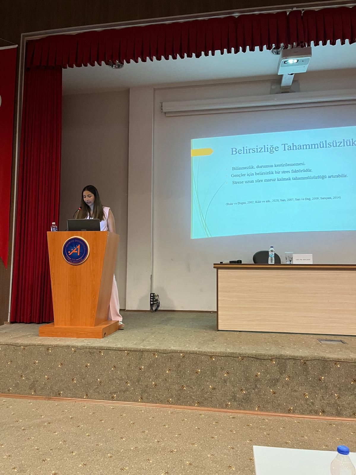Zeynep Özerol bir okul seminerinde kürsüde konuşurken